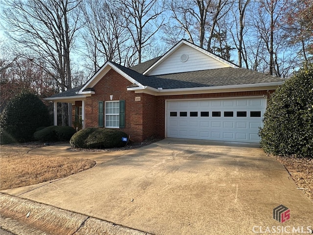 view of front of home with a shingled roof, brick siding, driveway, and an attached garage