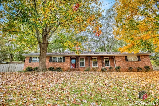 ranch-style home with brick siding and fence