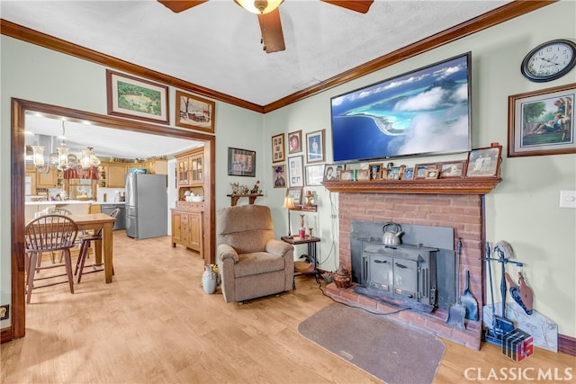 sitting room featuring ornamental molding, a wood stove, a textured ceiling, light wood-type flooring, and ceiling fan with notable chandelier