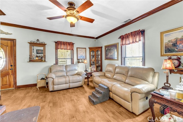 living room featuring light wood-style floors, visible vents, plenty of natural light, and ornamental molding