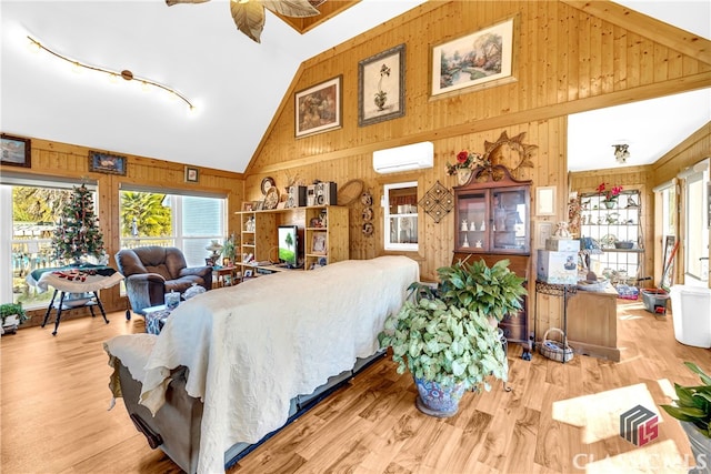 bedroom featuring an AC wall unit, high vaulted ceiling, wood finished floors, and wooden walls