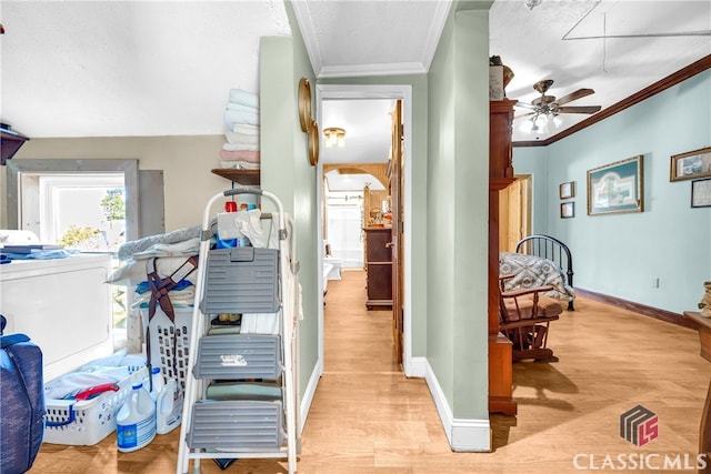 interior space with washer / clothes dryer, baseboards, light wood finished floors, attic access, and crown molding