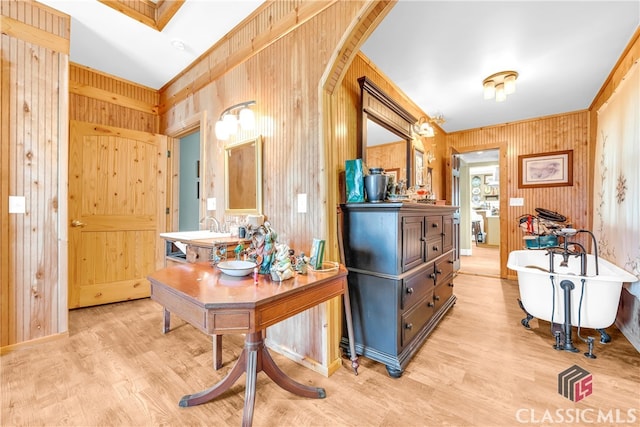 interior space featuring a freestanding bath, wooden walls, wood finished floors, and vanity