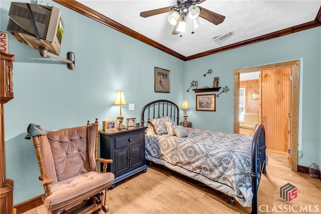 bedroom featuring baseboards, visible vents, a ceiling fan, ornamental molding, and light wood-type flooring