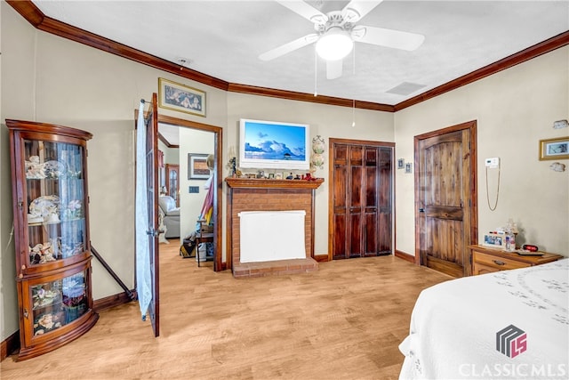 bedroom with baseboards, light wood finished floors, a fireplace, and crown molding