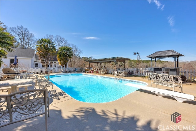 view of pool featuring a fenced in pool, a patio, fence, a pergola, and a diving board