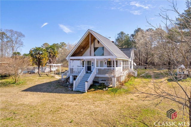 back of property featuring stairs, a porch, and a lawn