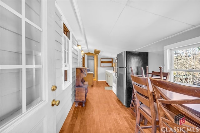 dining room with vaulted ceiling and light wood-style flooring