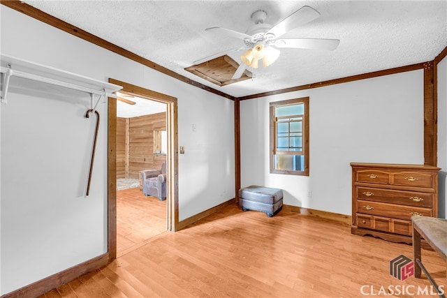 bedroom with light wood finished floors, ceiling fan, crown molding, and a textured ceiling