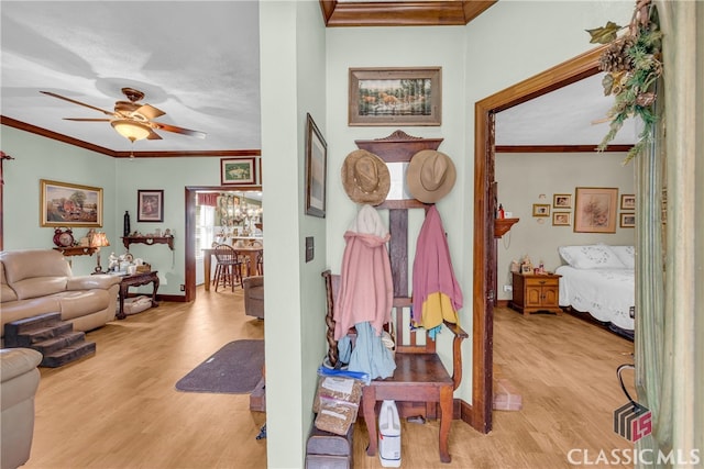 hallway featuring light wood-style flooring, ornamental molding, and baseboards