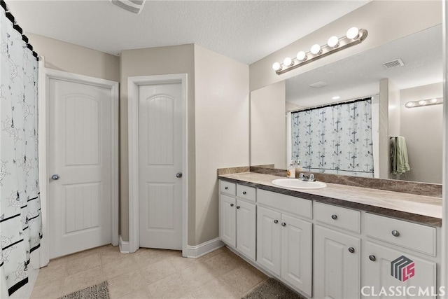 full bathroom featuring tile patterned flooring, visible vents, baseboards, and vanity