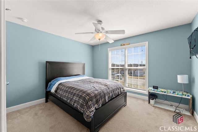 bedroom with a ceiling fan, light colored carpet, and baseboards