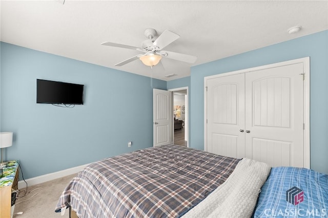 carpeted bedroom featuring a ceiling fan, baseboards, and a closet