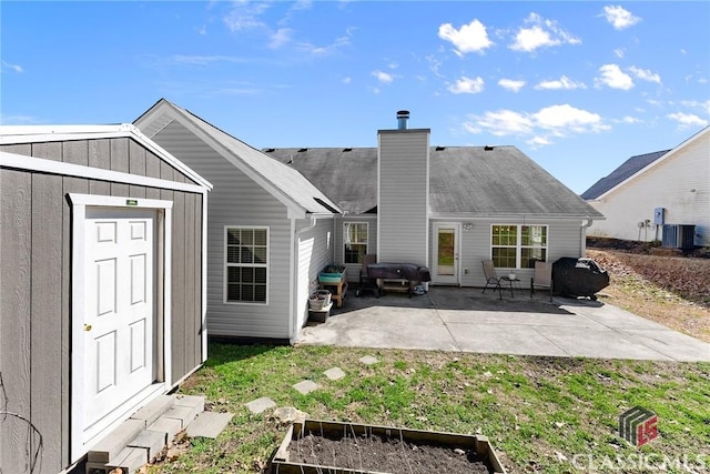 back of property featuring board and batten siding, central AC, a patio, and a chimney