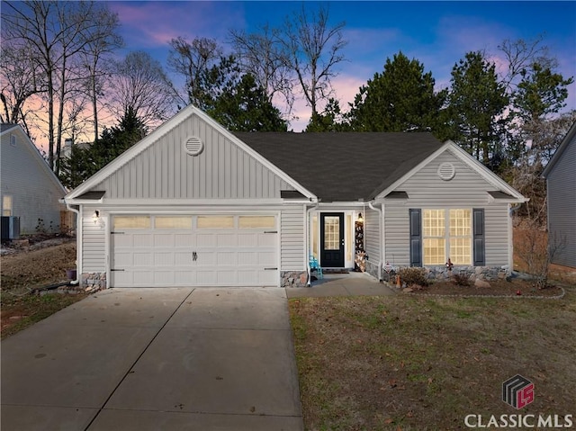 ranch-style house featuring a garage, concrete driveway, board and batten siding, and roof with shingles