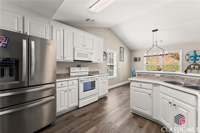 kitchen with dark wood finished floors, white cabinetry, vaulted ceiling, a sink, and white appliances