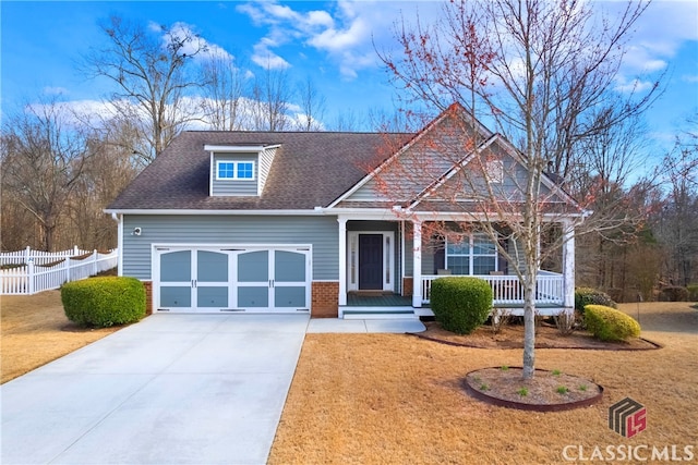 craftsman-style home with covered porch, a garage, brick siding, a shingled roof, and fence