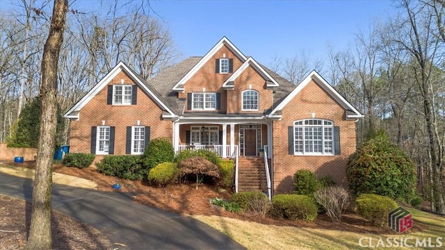 view of front of home featuring covered porch and brick siding