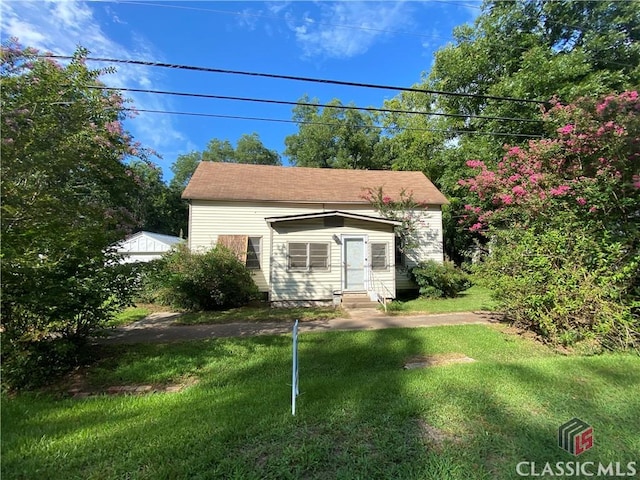 bungalow-style home featuring entry steps and a front lawn