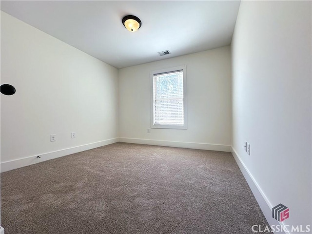 carpeted spare room featuring visible vents and baseboards