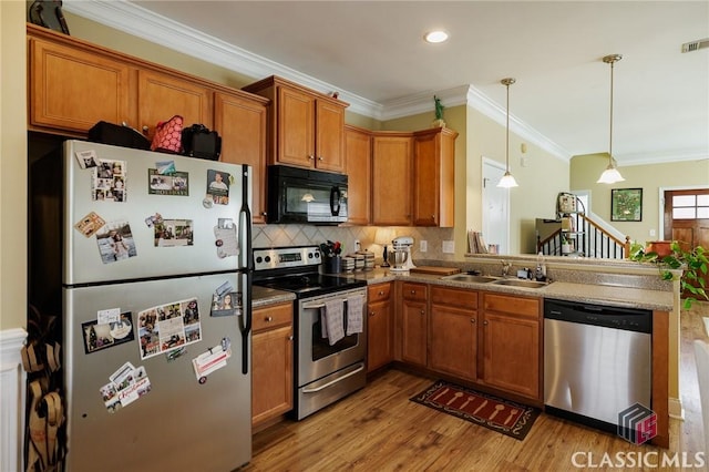 kitchen featuring backsplash, appliances with stainless steel finishes, brown cabinets, and a sink