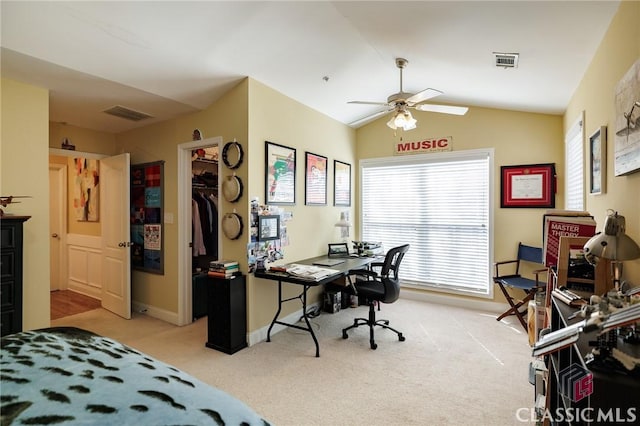 home office with a ceiling fan, lofted ceiling, light carpet, and visible vents