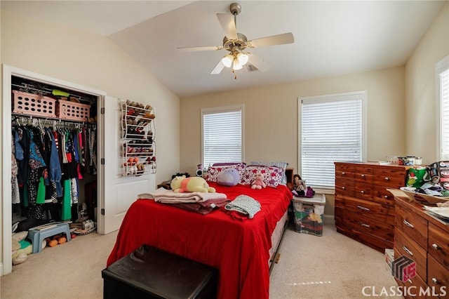 bedroom featuring ceiling fan, vaulted ceiling, a closet, and light colored carpet