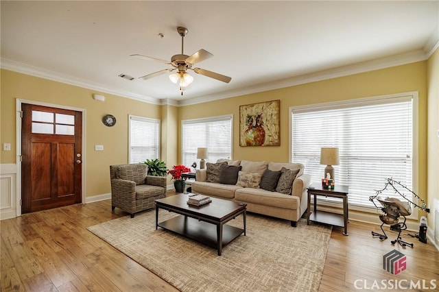 living area featuring a ceiling fan, crown molding, and light wood-style flooring