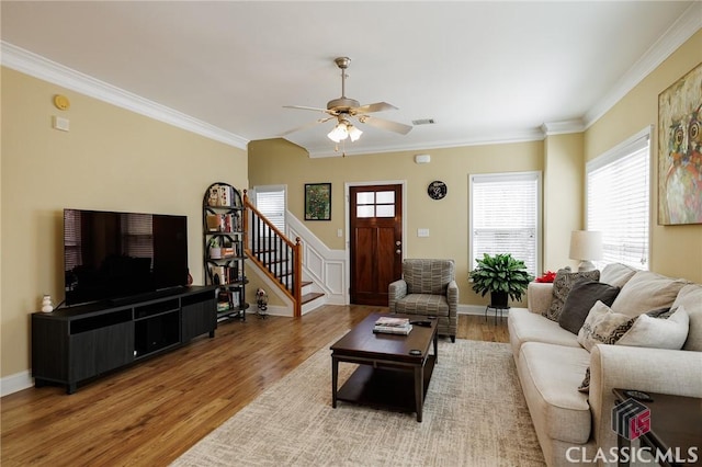 living room with ornamental molding, ceiling fan, stairway, and wood finished floors