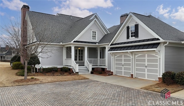 view of front of property with decorative driveway, a standing seam roof, and a chimney