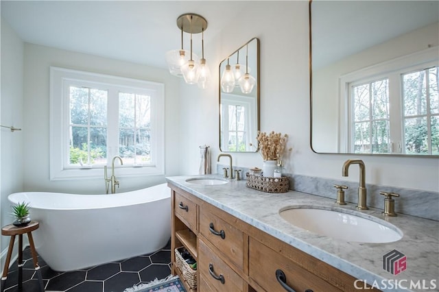 bathroom with a freestanding bath, double vanity, a sink, and tile patterned floors