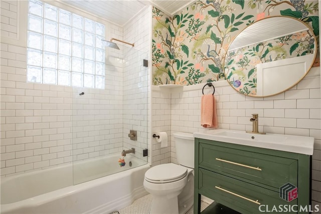 full bathroom with wallpapered walls, toilet, a wainscoted wall, tub / shower combination, and tile walls