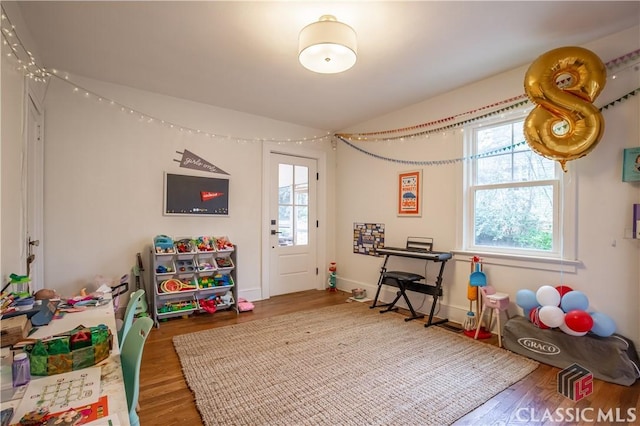 game room with lofted ceiling, baseboards, and wood finished floors