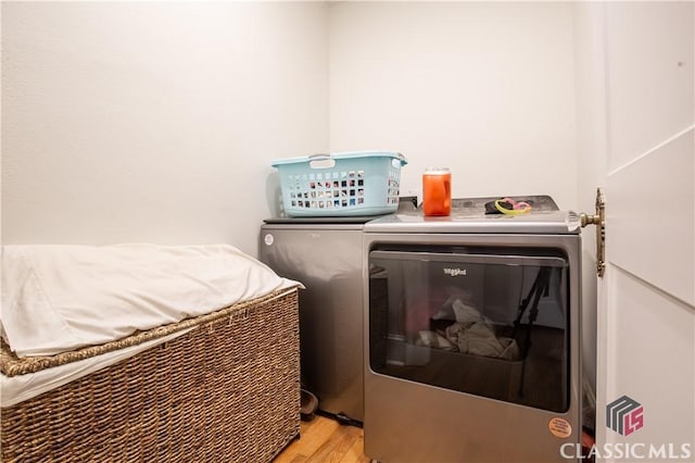 laundry room featuring laundry area, washing machine and dryer, and light wood-style flooring