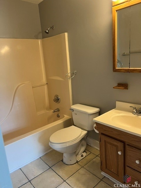 bathroom with bathtub / shower combination, toilet, vanity, baseboards, and tile patterned floors