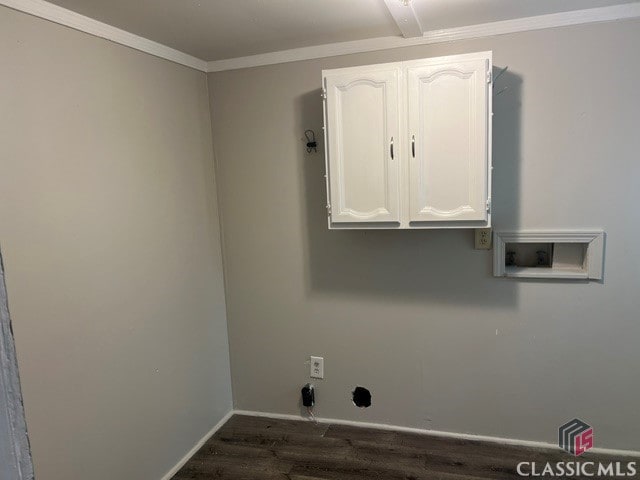 washroom featuring dark wood-type flooring, ornamental molding, washer hookup, and cabinet space