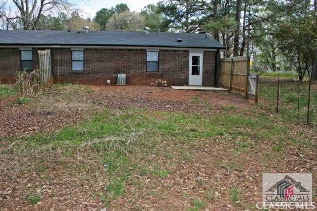 rear view of property with cooling unit, brick siding, fence, and a patio