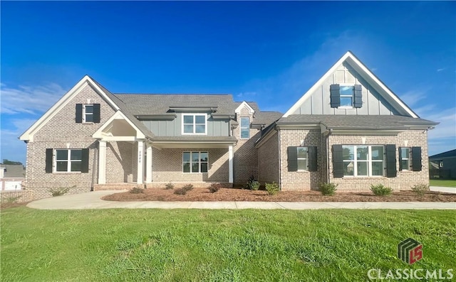 craftsman inspired home featuring brick siding, board and batten siding, and a front yard