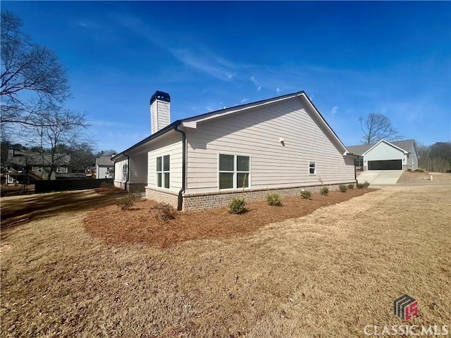 view of home's exterior with brick siding, a yard, and a chimney