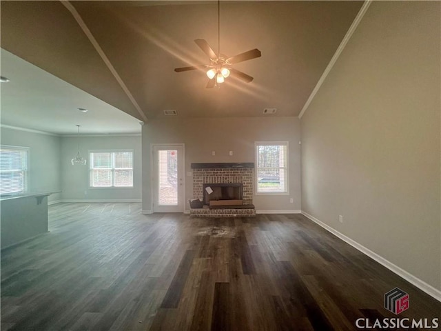 unfurnished living room featuring ornamental molding, plenty of natural light, dark wood-type flooring, and a fireplace