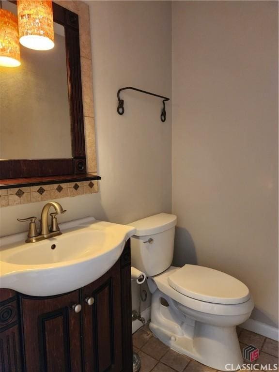 bathroom with tile patterned floors, tasteful backsplash, toilet, and vanity