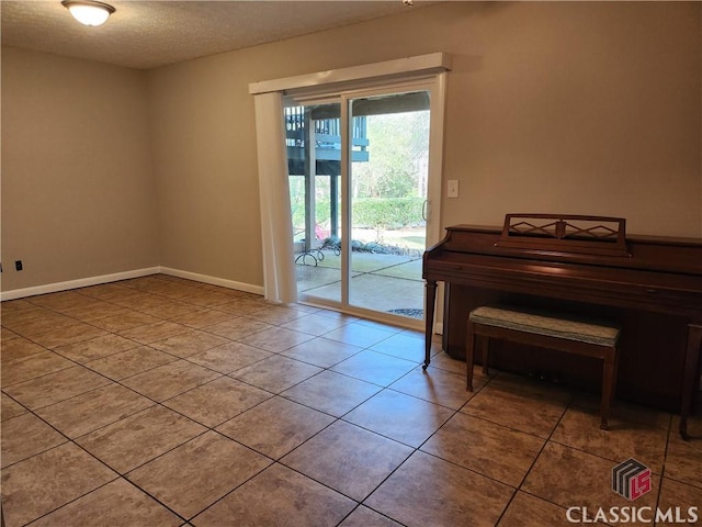 doorway to outside with tile patterned floors, baseboards, and a textured ceiling