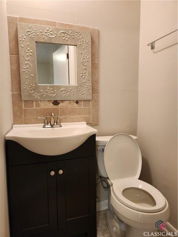 half bath with tasteful backsplash, vanity, and toilet