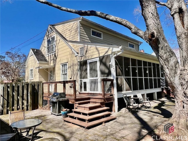 back of house with a sunroom, a patio, and fence