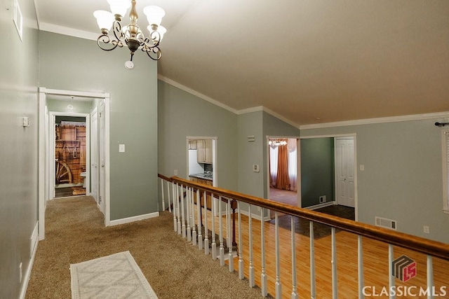 hall featuring ornamental molding, visible vents, vaulted ceiling, and a chandelier