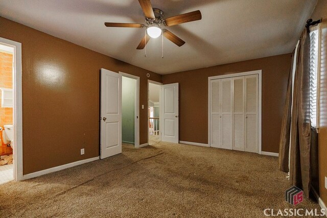 unfurnished bedroom with carpet floors, a closet, a ceiling fan, and baseboards