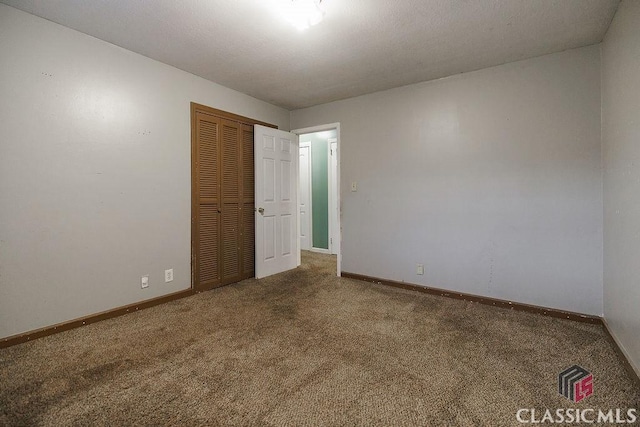 carpeted empty room with baseboards