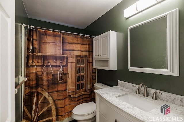 full bath featuring a shower with curtain, vanity, and toilet