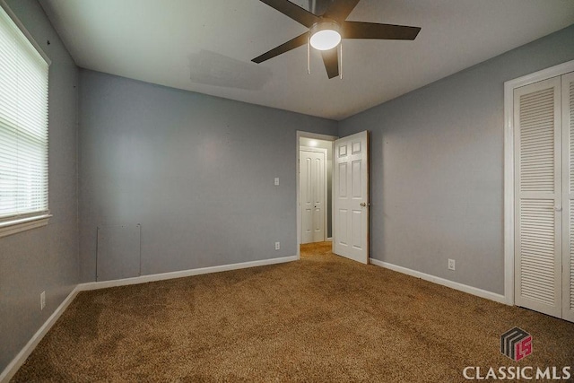 unfurnished bedroom featuring a ceiling fan, a closet, carpet flooring, and baseboards