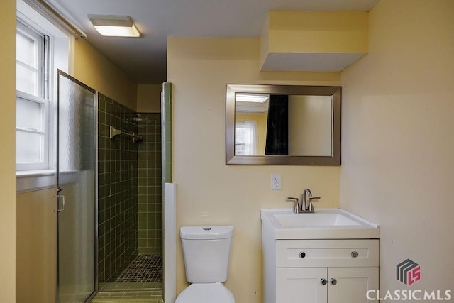 full bath with a stall shower, vanity, and toilet